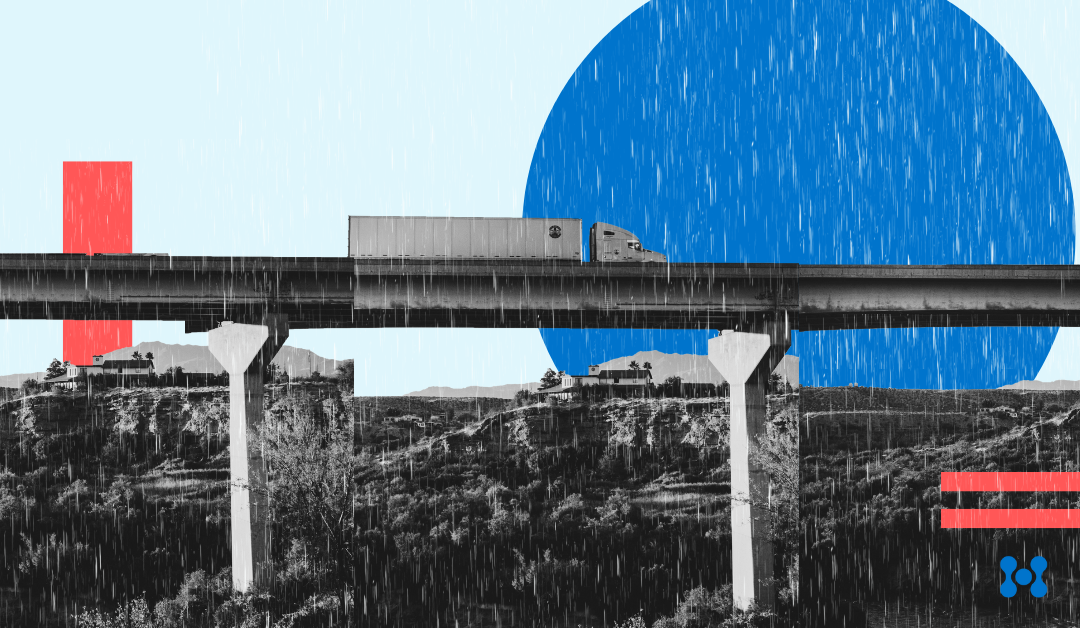 a semi-truck crosses a large bridge while rain falls.