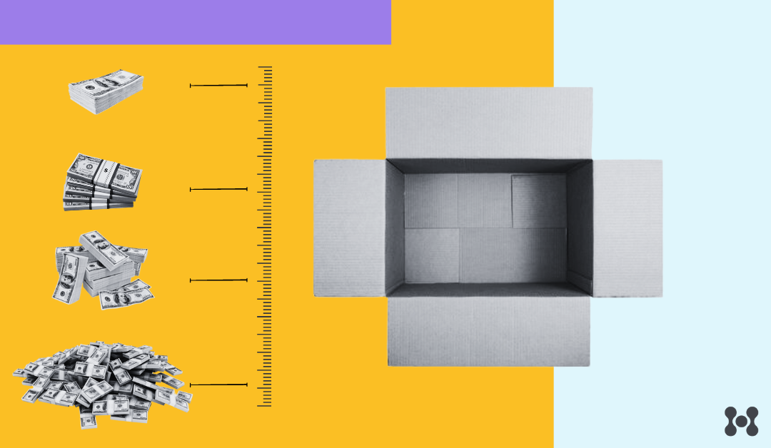 An open cardboard box is shown with a top down view. The box is empty, but there is a ruler to the left of the box, showing piles of money that vary in size depending on the box dimensions. 