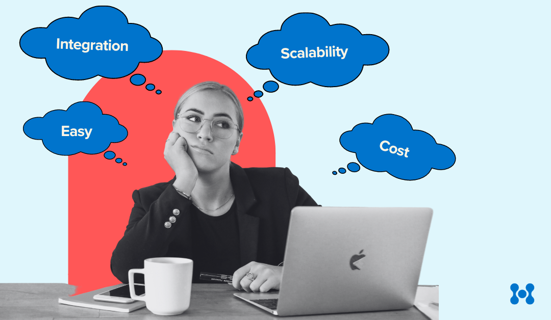 Choosing warehouse picking software. A woman sits at a table with her laptop and a cup of coffee. Thought bubbles appear around her head showing that she has questions over potential costs and barriers such as scalability and integration.